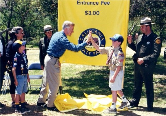 Governor Gray Davis giving a young boy a hi-five at a California State Park Event.